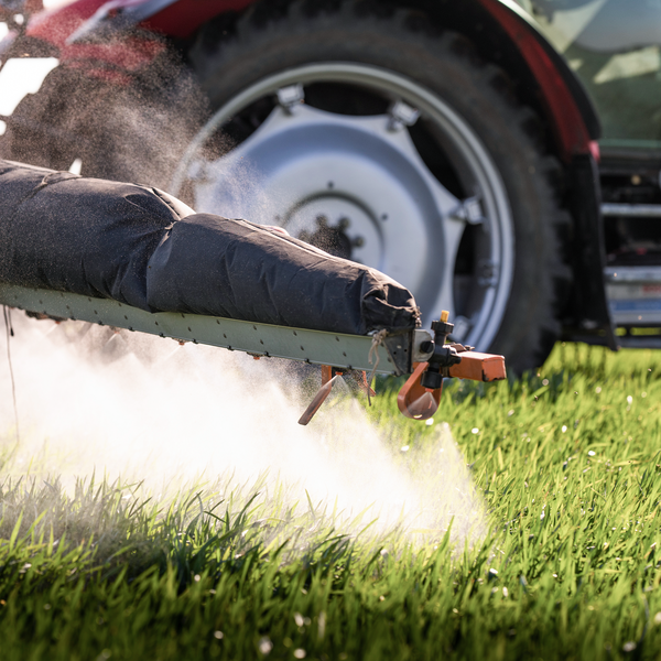 close-up of a tractor spraying a meadow with pesticides close-up of a tractor spraying a meadow with pesticides